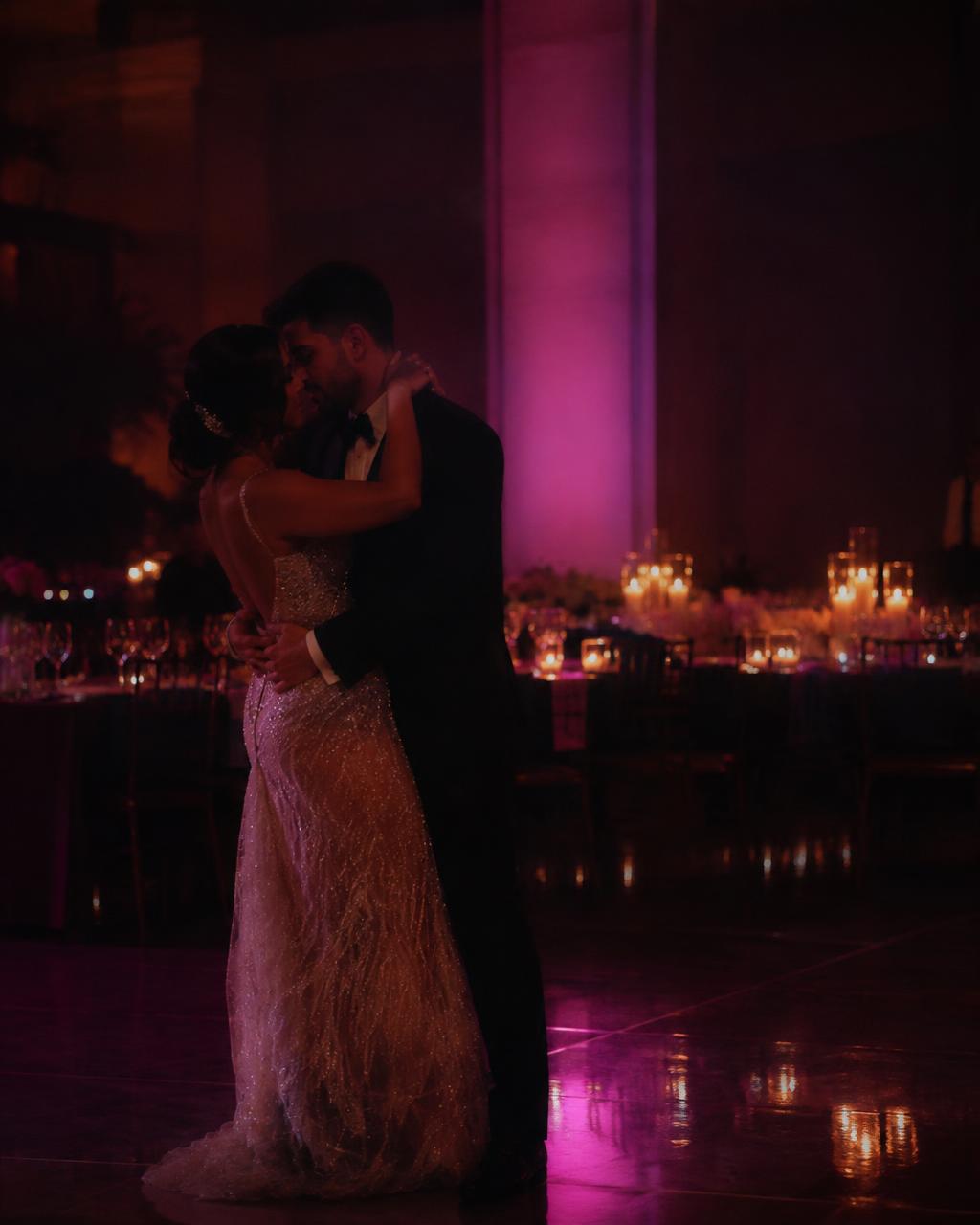 Intimate wedding reception with warm candlelight and a soft magenta wash